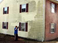 Before and after picture of siding being power washed.